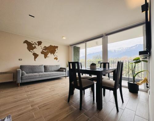ein Wohnzimmer mit Tisch und Stühlen und einer Couch in der Unterkunft Departamento vista cordillera alto la florida in Santiago
