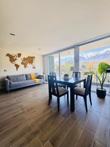 ein Esszimmer mit Tisch und Stühlen und einer Couch in der Unterkunft Departamento vista cordillera alto la florida in Santiago