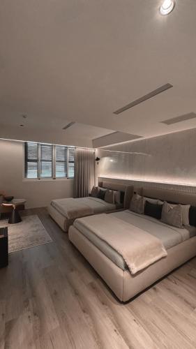 two beds in a large bedroom with wooden floors at Here Hotel 宅這兒私宅-屏市A宅 in Pingtung City