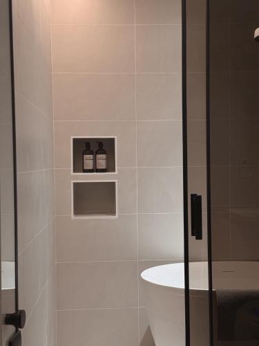 a bathroom with a shower with two bottles on shelves at Here Hotel 宅這兒私宅-屏市A宅 in Pingtung City