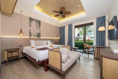 a hotel room with a bed and a couch at Howard Johnson by Wyndham Phuket Naiyang in Thalang