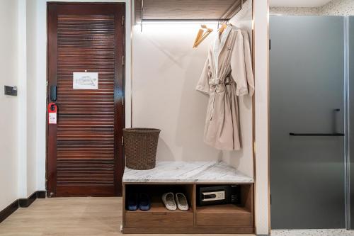 a room with a closet with a robe and shoes at Howard Johnson by Wyndham Phuket Naiyang in Thalang