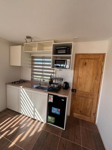 a small kitchen with a sink and a stove at Cabaña en Vallenar in Vallenar