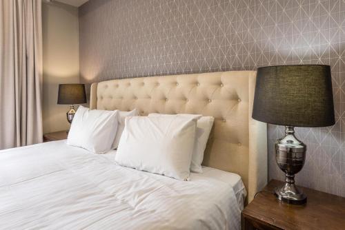 a bedroom with a large bed with white pillows at The Airport Stop Modern, 15min to Brisbane City in Brisbane