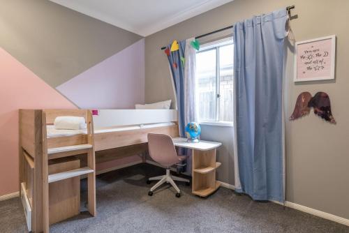 a bedroom with a desk and a bed and a window at The Airport Stop Modern, 15min to Brisbane City in Brisbane