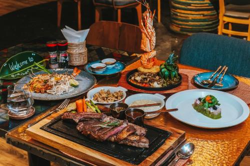 a table with plates of food on top of it at Hotel Indigo Phuket Patong by IHG in Patong Beach