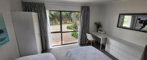 a bedroom with a bed and a desk and a window at Dewdrop Cottage in Hastings