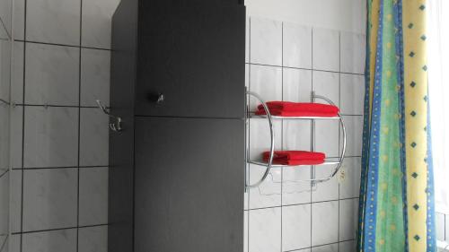 ein Badezimmer mit zwei roten Handtüchern auf einem Regal in der Unterkunft Hotel Leon in Biała Podlaska