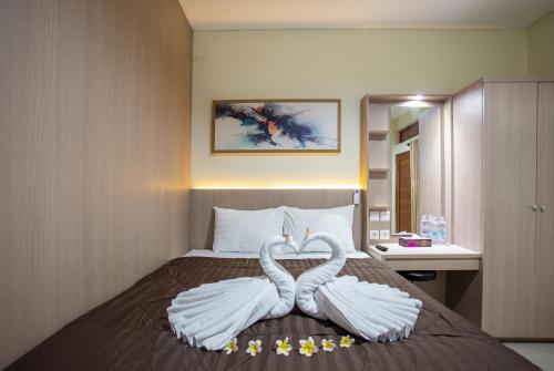 two swans made to look like birds sitting on a bed at Opang Asri Guesthouse Sanur in Sanur