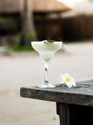 a wine glass sitting on a table with a flower at Wake Park Cambodia in Siem Reap