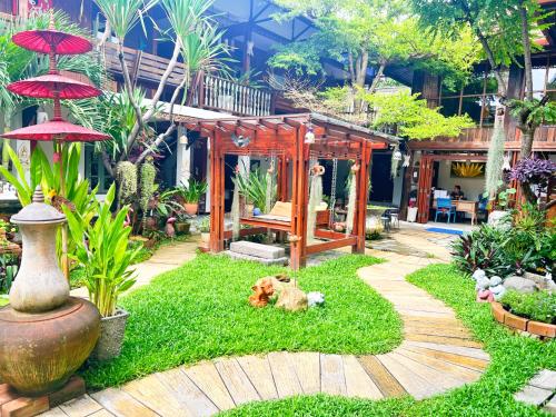 a garden with a small house in the middle at Pao Come Boutique House in Chiang Mai