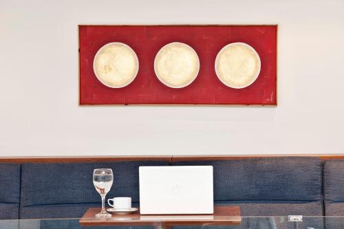 a picture of three plates on a table with a wine glass at Arion Athens Hotel in Athens
