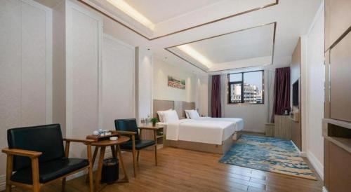 a hotel room with a bed and a table and chairs at Quanzhou Binhai Hotel in Quanzhou