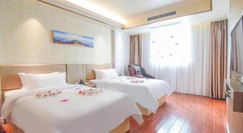 a hotel room with two beds and a window at Quanzhou Binhai Hotel in Quanzhou