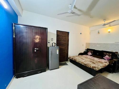 a bedroom with a bed and a large wooden door at premanand mharaj marg Vrindavan Dham in Vrindāvan