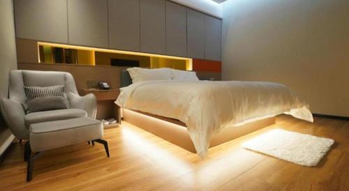 a bedroom with a large bed and a chair at Quanzhou Binhai Hotel in Quanzhou