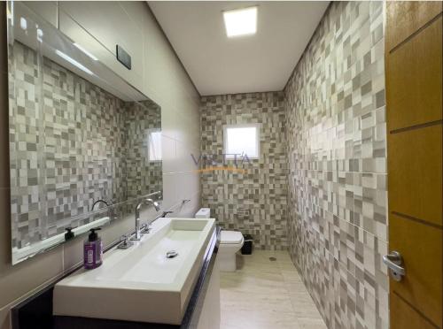 a bathroom with a sink and a toilet at Casa Aconchegante na Serra da Cantareira em Condomínio Fechado in Mairiporã