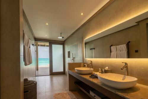 a bathroom with two sinks and a large mirror at Nala Maldives by Jawakara in Lhaviyani Atoll