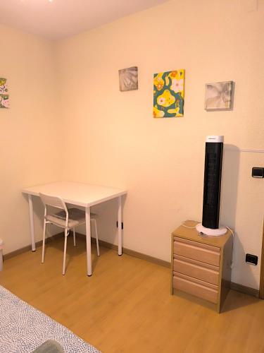 a room with a table and a tv on a cabinet at Amplia habitación en buena ubicación in Madrid