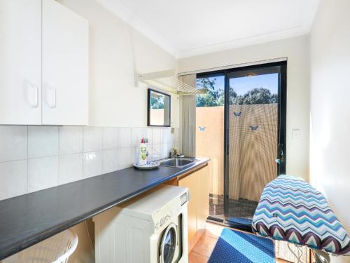 a kitchen with a sink and a washing machine at Enjoy Between Lake and River in South Yunderup