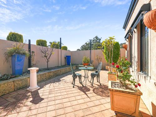 a patio with a table and chairs and a fence at Enjoy Between Lake and River in South Yunderup