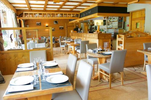 une salle à manger avec des tables et des chaises en bois dans l'établissement Hotel Le Christiania, aux Contamines-Montjoie