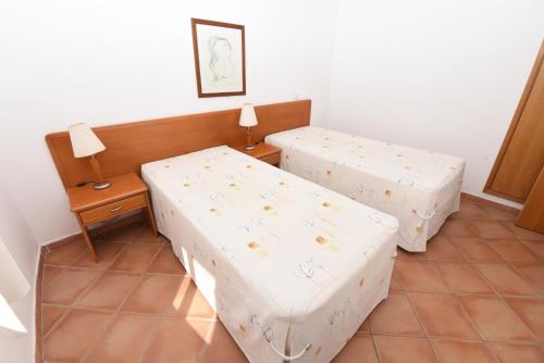a room with two beds and a table and lamp at Monte dos Avós Village - Pet Friendly in Tavira