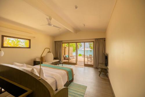 a bedroom with a bed and a view of the ocean at Nala Maldives by Jawakara in Lhaviyani Atoll