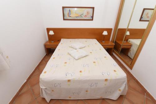a bedroom with a bed in front of a mirror at Monte dos Avós Village - Pet Friendly in Tavira
