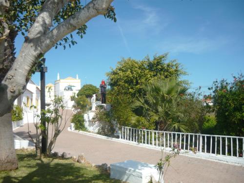 a street with a white fence and trees and a building at Monte dos Avós Village - Pet Friendly in Tavira