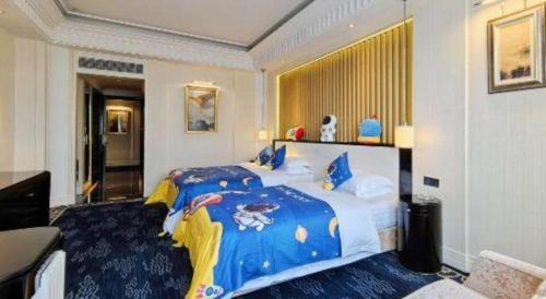 a bedroom with a large bed with a blue blanket at Tongxiang Inspirock Hotel in Jiaxing