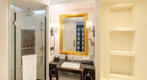 a bathroom with a sink and a mirror and a shower at Tongxiang Inspirock Hotel in Jiaxing