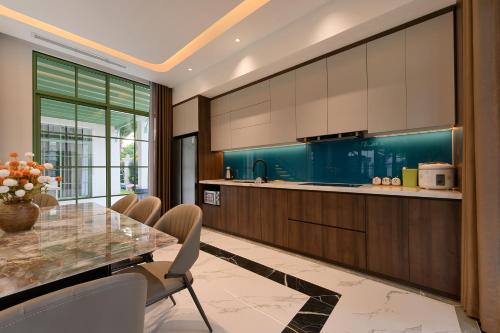 a kitchen with a table and chairs and a counter at La isla Apartments & Villas - Sea View & Fireworks Phu Quoc in Phu Quoc
