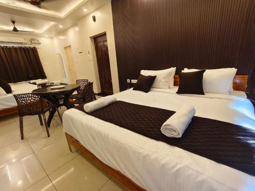 a large bed in a room with a table at Sai RBM Grand Inn in Kuilapayam