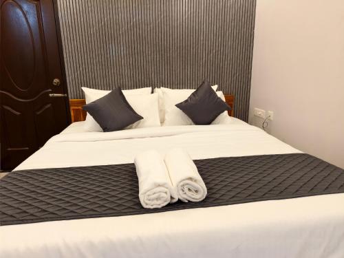 a bedroom with a bed with two towels on it at Sai RBM Grand Inn in Kuilapayam