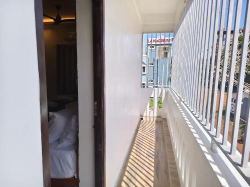 a room with a balcony with a bed and a window at Sai RBM Grand Inn in Kuilapayam
