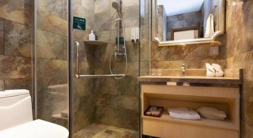 a bathroom with a shower and a toilet and a sink at Leisurely Hotel Shenzhen in Shenzhen