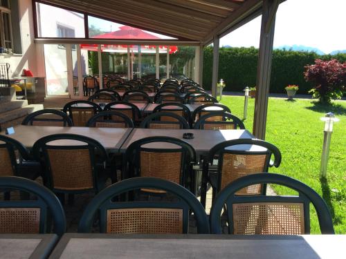 a row of tables and chairs under a gazebo at Hôtel - Restaurant Le Manoir in Vaulruz