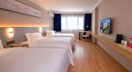 a hotel room with two beds and a television at danfeng kelly hotel in Shenzhen