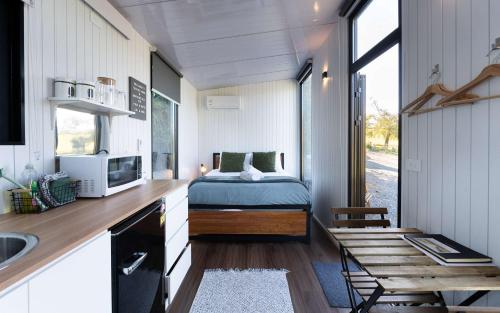 a small bedroom with a bed in a tiny house at Tussock Views by Tiny Away in Burkes Pass