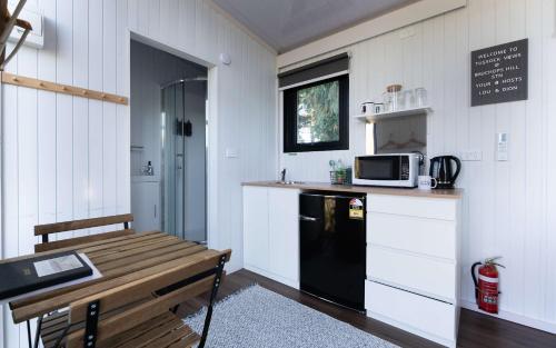 a kitchen with a black refrigerator and a microwave at Tussock Views by Tiny Away in Burkes Pass