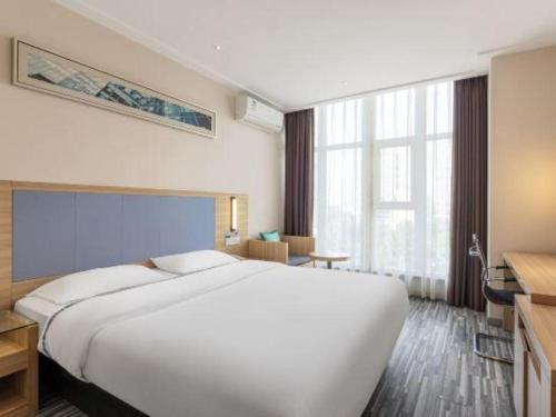 a large white bed in a hotel room at City Comfort Inn Wuhan Dongwu Avenue Light Rail Station in Wuhan