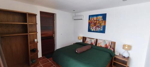 a bedroom with a green bed in a room at Alma Sunset Luxury Villas Lombok in Teluk Nara