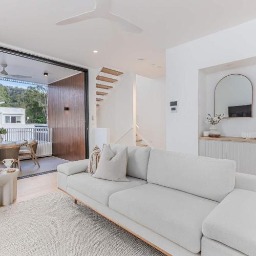 a white living room with a white couch at Urbanstayz - Lakehouse No 2- Lakefront Luxury Escape Villa - Pet Friendly in Cabarita Beach