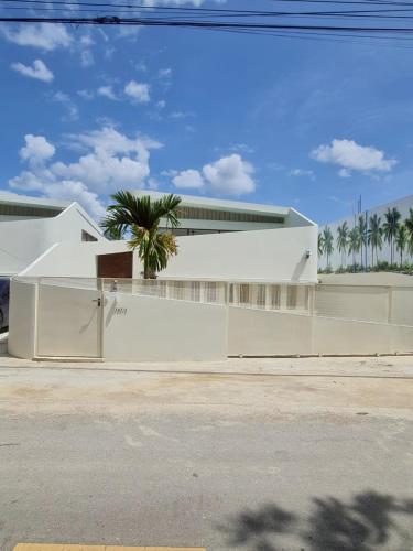 Un edificio blanco con palmeras delante. en SandScape Pool Villa B, en Ban Nong Khao Nieo