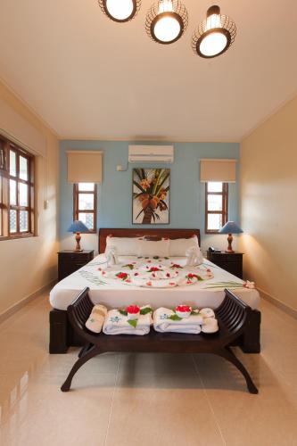 a bedroom with a large bed with towels on it at Le Relax Self Catering Apartment in La Digue