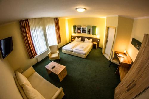 a hotel room with a bed and a couch at Gästehaus Blaue Ecke in Adenau