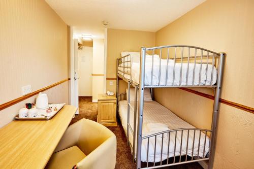 a small room with two bunk beds and a desk at Abbotsford Hotel in Dumbarton