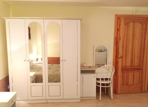 ein Schlafzimmer mit einem Bett und einem weißen Schrank in der Unterkunft Vaivorykštė in Nida