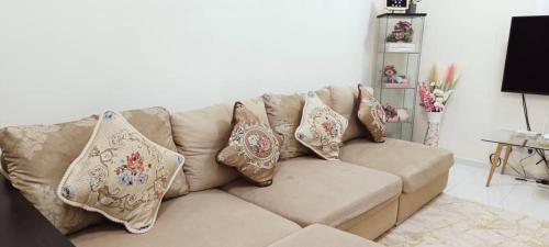 a couch with pillows on it in a living room at Bumiemas Homestay - 2 BEDROOM in Kangar